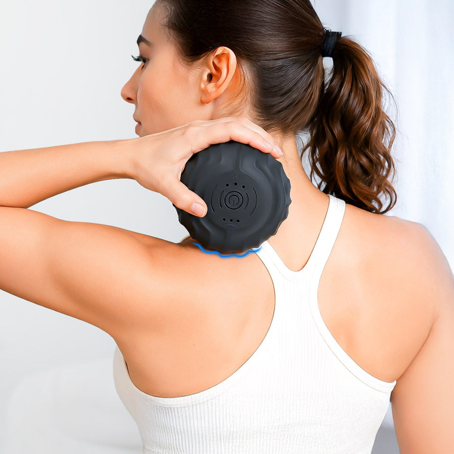 Woman holding the RECOVERO TRIGGER POINT ROLL against the top of her shoulder