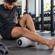 Man using the RECOVERO ROLL under his calf after training