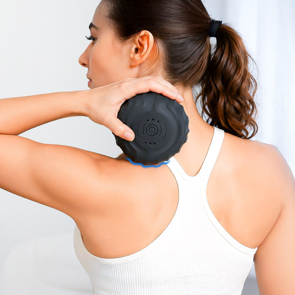 Woman holding the RECOVERO TRIGGER POINT ROLL against the top of her shoulder
